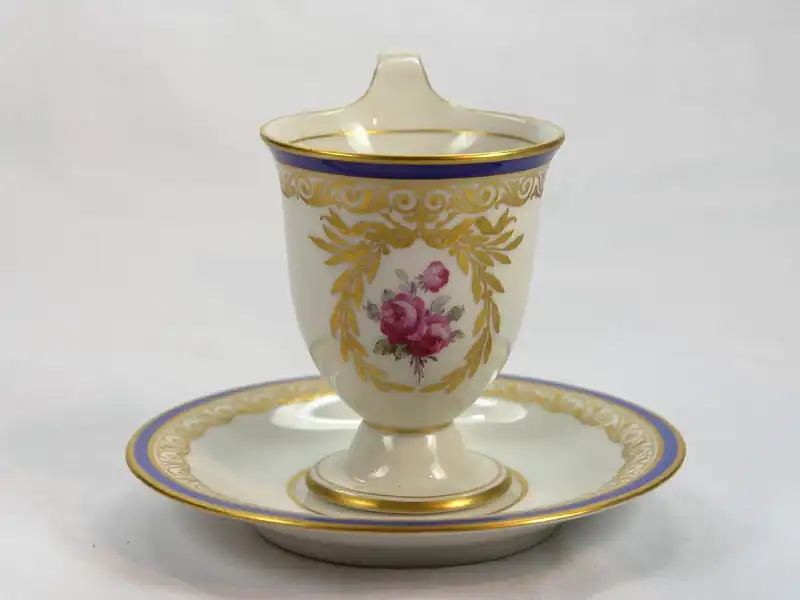 3 Tassen und Untertassen, um 1914/17, gemarkt KPM, auf Schauseiten in goldumrandeten Kartuschen Blumenmalerei (Veilchen und Rosen), Tassenrand und Unterteller mit Goldornamentik und blauem Rand verziert, unbeschädigt. H: 11 cm 4