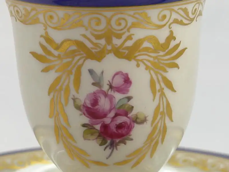 3 Tassen und Untertassen, um 1914/17, gemarkt KPM, auf Schauseiten in goldumrandeten Kartuschen Blumenmalerei (Veilchen und Rosen), Tassenrand und Unterteller mit Goldornamentik und blauem Rand verziert, unbeschädigt. H: 11 cm 5