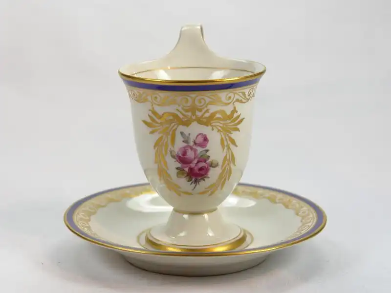 3 Tassen und Untertassen, um 1914/17, gemarkt KPM, auf Schauseiten in goldumrandeten Kartuschen Blumenmalerei (Veilchen und Rosen), Tassenrand und Unterteller mit Goldornamentik und blauem Rand verziert, unbeschädigt. H: 11 cm 6