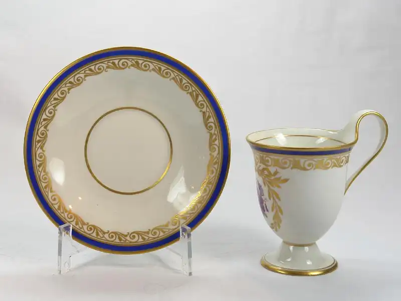 3 Tassen und Untertassen, um 1914/17, gemarkt KPM, auf Schauseiten in goldumrandeten Kartuschen Blumenmalerei (Veilchen und Rosen), Tassenrand und Unterteller mit Goldornamentik und blauem Rand verziert, unbeschädigt. H: 11 cm 7