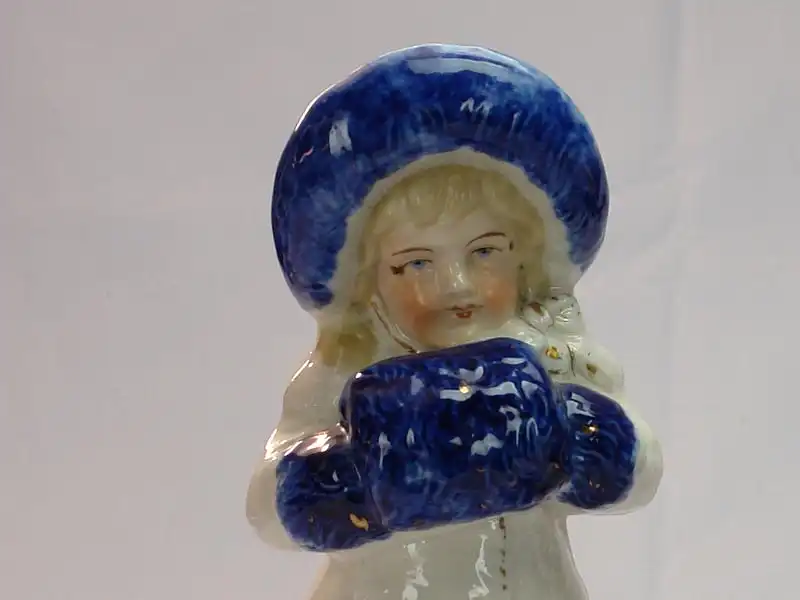Paar Porzellanfiguren, um 1900, ungemarkt, Mädchen und Junge in Wintersachen, blau-weiß bemalt, im Fuß des Mädchens Brandrisse, sonst unbeschädigt. H: 22 cm 1