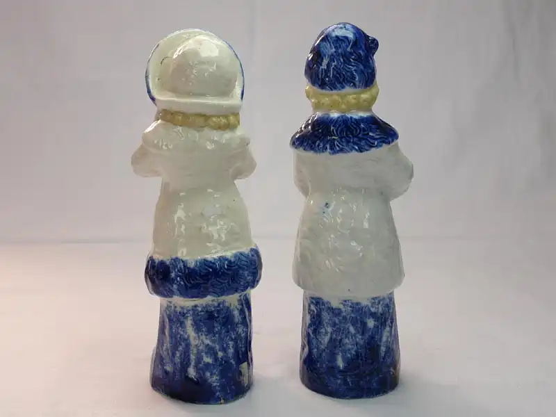 Paar Porzellanfiguren, um 1900, ungemarkt, Mädchen und Junge in Wintersachen, blau-weiß bemalt, im Fuß des Mädchens Brandrisse, sonst unbeschädigt. H: 22 cm 3