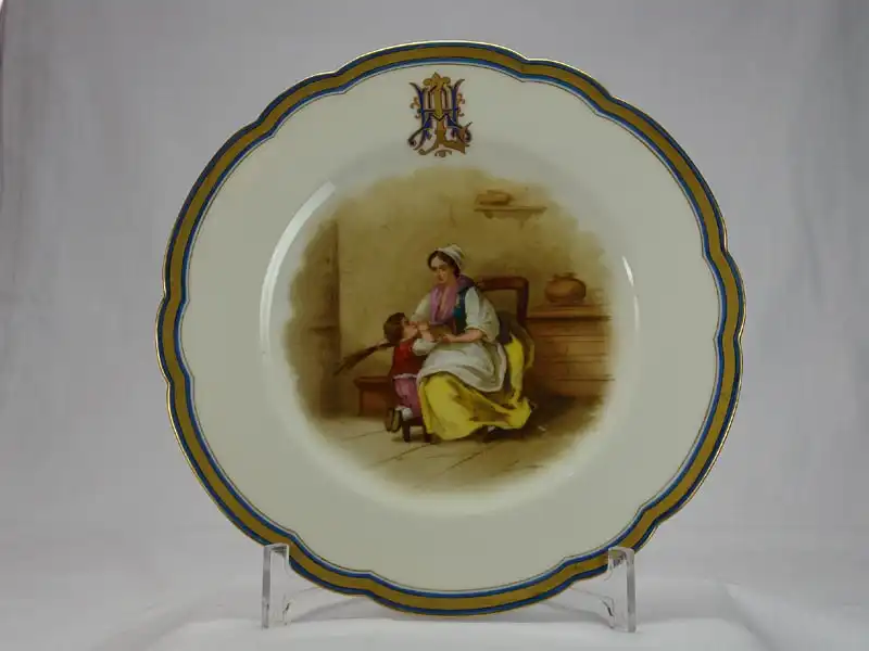 Paar Zierteller, um 1880, gemarkt mit grüner Marke H & C¡, für David Haviland Limoges und rotem Stempel W. Guerin & Cie, Paris & Limoges, Besitzermonogramm auf der Fahne, handgemalter Dekor, im Spiegel Frau mit Knaben. D: 24 cm 1
