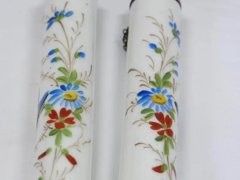 Zwei Porzellankerzen, Ende 19. Jh., wohl Frankreich, mit Blumenranken und Schmetterlingen bemalt, mit Petroleum befüllbar, ein Haarriß. H: 19 cm 2