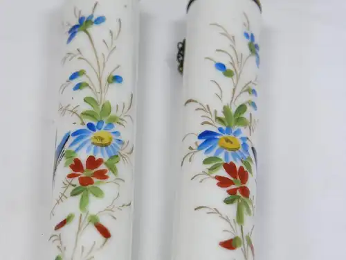 Zwei Porzellankerzen, Ende 19. Jh., wohl Frankreich, mit Blumenranken und Schmetterlingen bemalt, mit Petroleum befüllbar, ein Haarriß. H: 19 cm