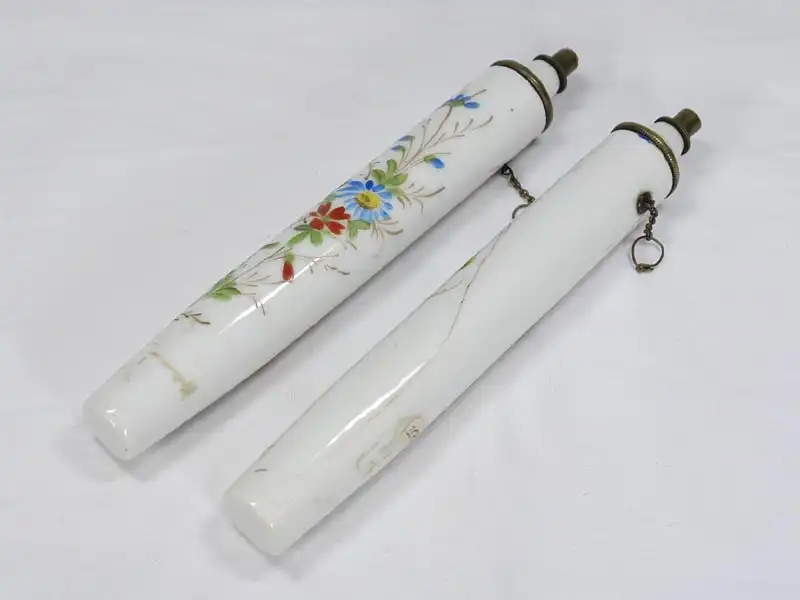 Zwei Porzellankerzen, Ende 19. Jh., wohl Frankreich, mit Blumenranken und Schmetterlingen bemalt, mit Petroleum befüllbar, ein Haarriß. H: 19 cm 4