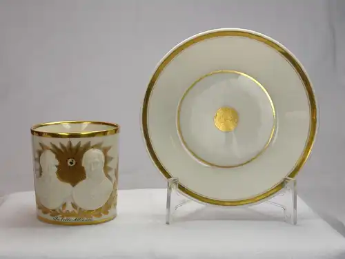 Tasse und Untertasse, deutsch, um 1815-20, ungemarkt, im Stil von Sevres, zylindrische Form, verziert mit Halbportraits von Wellington und Blücher in Biskuitporzellan vor einer goldenen Sonne, umrandet von goldenen Lorbeerzweigen, bezeichnet "La...