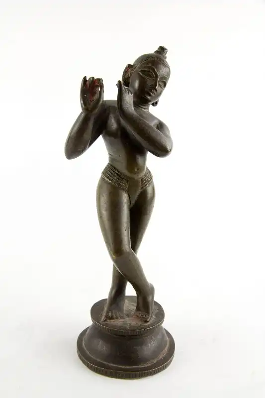 Krishna, Indien, 18./19. Jh., wohl Bengalen, mit Resten von schwarzer und roter Bemalung, schöne Patina, Gebrauchsspuren, Flöte fehlt. H: 24,5 cm. Für weitere Fragen stehen wir Ihnen gern zur Verfügung. 0