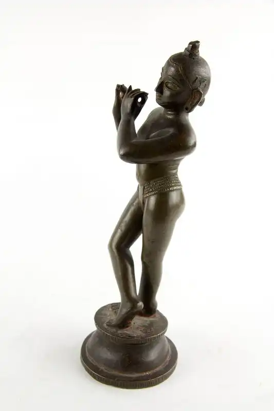 Krishna, Indien, 18./19. Jh., wohl Bengalen, mit Resten von schwarzer und roter Bemalung, schöne Patina, Gebrauchsspuren, Flöte fehlt. H: 24,5 cm. Für weitere Fragen stehen wir Ihnen gern zur Verfügung. 1
