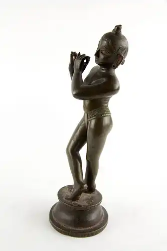 Krishna, Indien, 18./19. Jh., wohl Bengalen, mit Resten von schwarzer und roter Bemalung, schöne Patina, Gebrauchsspuren, Flöte fehlt. H: 24,5 cm. Für weitere Fragen stehen wir Ihnen gern zur Verfügung.