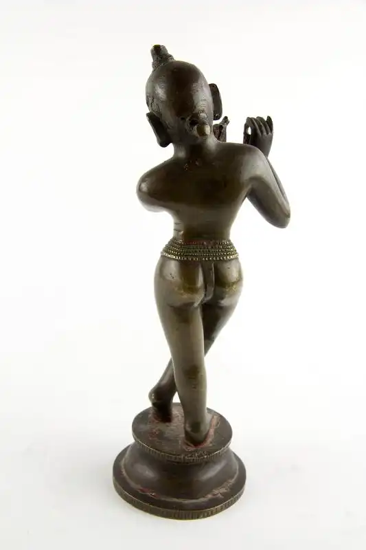Krishna, Indien, 18./19. Jh., wohl Bengalen, mit Resten von schwarzer und roter Bemalung, schöne Patina, Gebrauchsspuren, Flöte fehlt. H: 24,5 cm. Für weitere Fragen stehen wir Ihnen gern zur Verfügung. 2