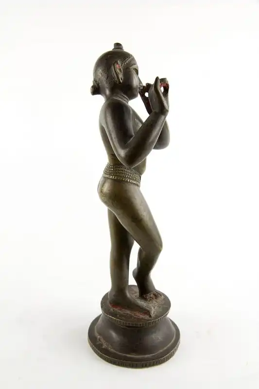 Krishna, Indien, 18./19. Jh., wohl Bengalen, mit Resten von schwarzer und roter Bemalung, schöne Patina, Gebrauchsspuren, Flöte fehlt. H: 24,5 cm. Für weitere Fragen stehen wir Ihnen gern zur Verfügung. 3