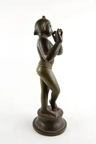 Krishna, Indien, 18./19. Jh., wohl Bengalen, mit Resten von schwarzer und roter Bemalung, schöne Patina, Gebrauchsspuren, Flöte fehlt. H: 24,5 cm. Für weitere Fragen stehen wir Ihnen gern zur Verfügung.