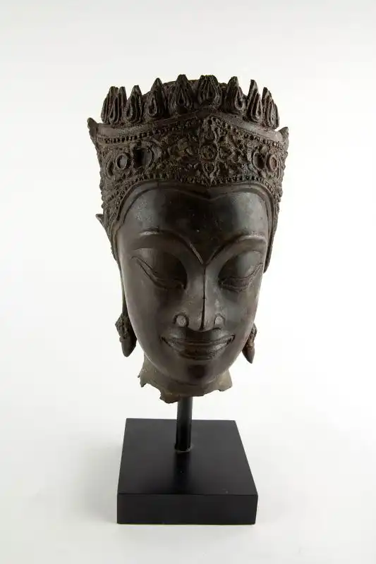 Buddha-Kopf, Thailand, Ayutthaya Periode (1350-1767), 17./18. Jh., Kopf mit königlischer Krone, Spitze fehlt, Reste von roter Kultfarbe, Ausgrabungsstück mit schön gewachsener Patina. H: gesamt 32 cm, Kopfhöhe: 22 cm 0