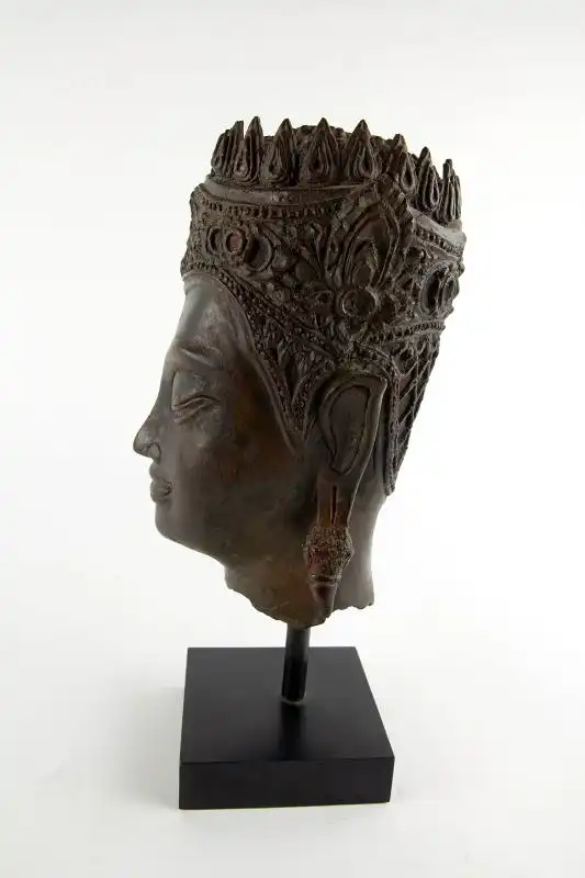 Buddha-Kopf, Thailand, Ayutthaya Periode (1350-1767), 17./18. Jh., Kopf mit königlischer Krone, Spitze fehlt, Reste von roter Kultfarbe, Ausgrabungsstück mit schön gewachsener Patina. H: gesamt 32 cm, Kopfhöhe: 22 cm 1