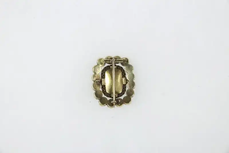 Brosche, England, viktorianisch, 14 Karat Gold, oval besetzt mit Burmarubinen- und Süßwasserperlenring, dazwischen geflochtenes Haar, sehr feine Qualität, Tragespuren. H: 2,7 cm, B: 2,4 cm 1