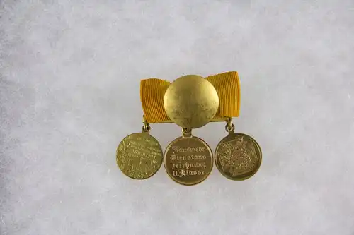 Miniaturspange mit aufgelegten Bändern, Preußen, 1870, Miniaturen zu den Orden: 1. Kriegsgedenkmünze für Kämpfer 1870/71, 2. Landwehrauszeichnung 2. Klasse, Bronze, 3. Zentenarmedaille 1897, Bronze vergoldet, guter Zustand