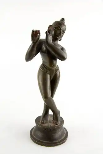 Krishna,
Indien, 18./19. Jh., wohl Bengalen, mit Resten von schwarzer und roter Bemalung, schöne Patina, Gebrauchsspuren, Flöte fehlt.
H: 24,5 cm