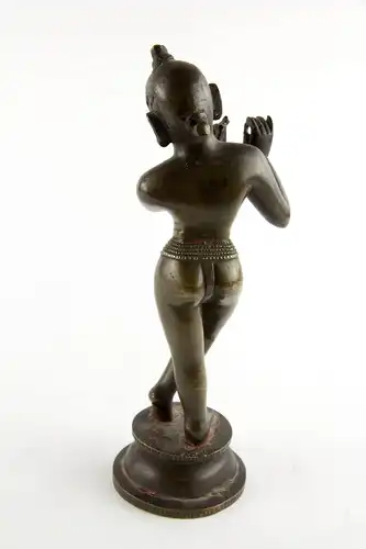Krishna,
Indien, 18./19. Jh., wohl Bengalen, mit Resten von schwarzer und roter Bemalung, schöne Patina, Gebrauchsspuren, Flöte fehlt.
H: 24,5 cm