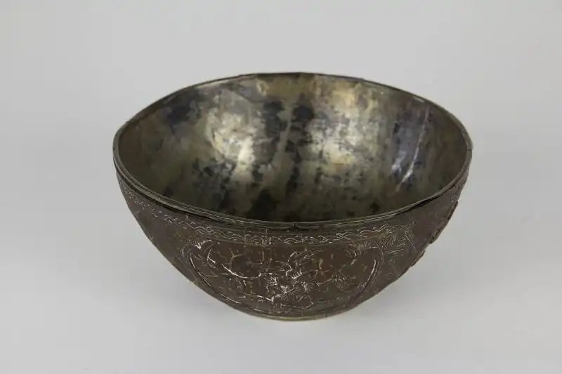 Schale, China, 19. Jh., fein mit Blumen und Ornamenten  beschnitzte Kokosnuss, mit Silberblech ausgeschlagen, Ausbruch am Rand, sonst guter Zustand. D: 13 cm, 

Bowl, China, 19th century, with flowers and ornaments graved coconut, inside a thin silver b 0