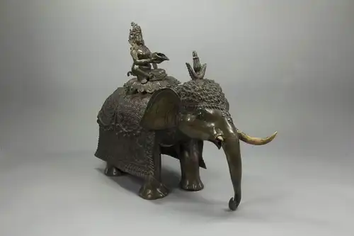 Bronze, wohl Nepal?, 19. Jh., sitzende Bodhisattva mit Kaurimuschel auf Elefant, feiner Bronzeguss, Bodhisattva mehrfach unfachmännisch mit Schrauben befestigt, Mandorla und ein Stoßzahn fehlen, sehr dekoratives Stück. H: 37 cm