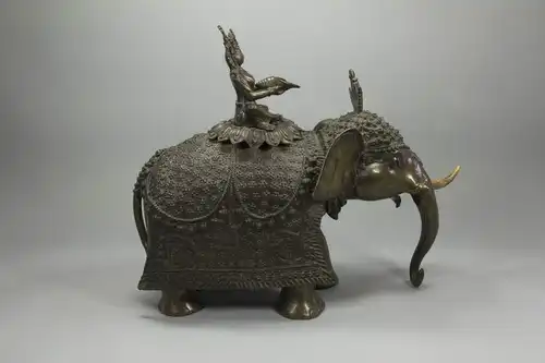 Bronze, wohl Nepal?, 19. Jh., sitzende Bodhisattva mit Kaurimuschel auf Elefant, feiner Bronzeguss, Bodhisattva mehrfach unfachmännisch mit Schrauben befestigt, Mandorla und ein Stoßzahn fehlen, sehr dekoratives Stück. H: 37 cm