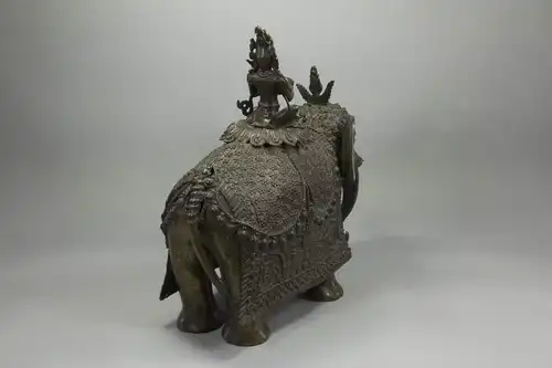 Bronze, wohl Nepal?, 19. Jh., sitzende Bodhisattva mit Kaurimuschel auf Elefant, feiner Bronzeguss, Bodhisattva mehrfach unfachmännisch mit Schrauben befestigt, Mandorla und ein Stoßzahn fehlen, sehr dekoratives Stück. H: 37 cm