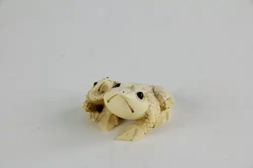 Netsuke,

Japan, Edo Meijij, Elfenbein, signiert, Kröte mit Jungtier, geschnitzt, dunkel eingelegte Augen, Gebrauchsspuren.

H: 2,5 cm