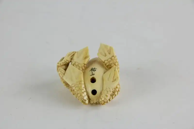 Netsuke,

Japan, Edo Meijij, Elfenbein, signiert, Kröte mit Jungtier, geschnitzt, dunkel eingelegte Augen, Gebrauchsspuren.

H: 2,5 cm 3