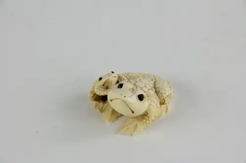 Netsuke,

Japan, Edo Meijij, Elfenbein, signiert, Kröte mit Jungtier, geschnitzt, dunkel eingelegte Augen, Gebrauchsspuren.

H: 2,5 cm