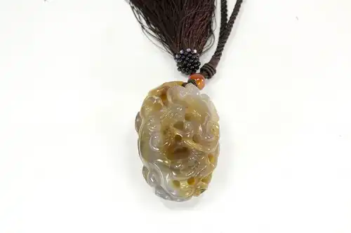 Handschmeichler,
China, 20. Jh, Achat, geschnittener Drache, rückseitig mit Lotusblüte verziert, Trageschlaufe mit Quaste, guter Zustand. 

L: 8 cm