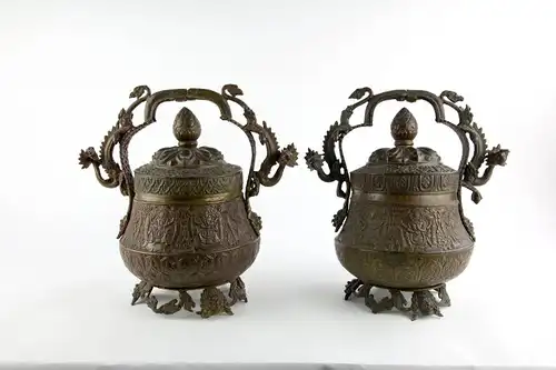 2 Deckelgefäße, Tibet, 19./20. Jh., Messing getrieben, verziert mit verschiedenen Heiligendarstellungen und Ornamenten, gegossene Griffe, als Drachen plastisch ausgearbeitet, wohl Körnerschalen für religiöse Zeremonien, ein Henkel locker,...