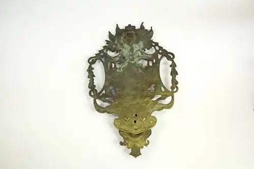 Wandapplikation, Frankreich, 17./18. Jh., Bronze, in der Mitte das französische Wappen, bekrönt von 2 Putten, und dem Portrait von Ludwig dem XIV, flankiert von Wappen und Kriegsgirlanden, im Unterteil Frauenkopf, Leuchterarm fehlt, Rest einer...