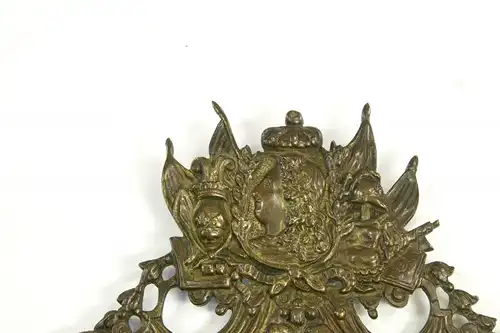 Wandapplikation, Frankreich, 17./18. Jh., Bronze, in der Mitte das französische Wappen, bekrönt von 2 Putten, und dem Portrait von Ludwig dem XIV, flankiert von Wappen und Kriegsgirlanden, im Unterteil Frauenkopf, Leuchterarm fehlt, Rest einer...