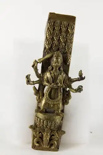 Beschlag, wohl Nepal. 20. Jh., Bronze, mehrarmige Götterfigur (Durga), geschnitten und graviert, auf Lotussockel, mit Inschrift. 
L: 18 cm, B: 7,5 cm