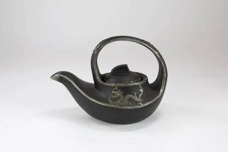 Teekanne,	19./20. Jh., China, Keramik, mit Weissmetalladern an den Rändern, Phönix, Drache und Ornamenten verziert, guter Zustand. H: 16 cm, 
Teapot, 19th/20th century, China, ceramic. 0