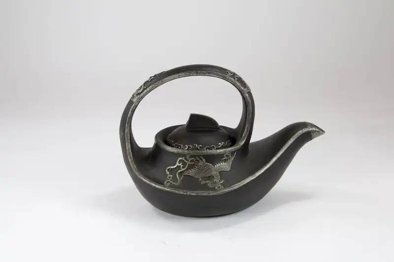 Teekanne,	19./20. Jh., China, Keramik, mit Weissmetalladern an den Rändern, Phönix, Drache und Ornamenten verziert, guter Zustand. H: 16 cm, 
Teapot, 19th/20th century, China, ceramic. 1