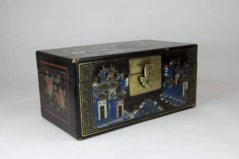 Holzkästchen, China, 19. Jh./20. Jh., mit Leinen bezogen, schwarz grundiert und mit feiner Landschaftsmalerei verziert, Deckel defekt, Gebrauchsspuren.H: 16 cm, B: 35 cm, T: 18 cm 1