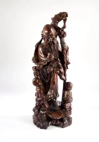 Figur, China, 20. Jh., geschnitzt, Rosenholz, Shoulao, Gott der Langlebigkeit mit Drachenstab und 2 Kindern, feine Schnitzerei, Augen aus Bein eingesetzt, Trockenrisse, guter Zustand. H: 54 cm