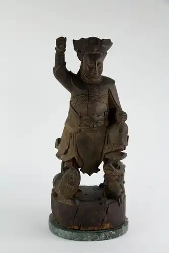Figur, China, wohl Ming Dynastie (1368 bis 1644), Holz, geschnitzt, Tempelfigur, Wächter, auf Löwen und Drachen stehend, ursprünglich farblich gefasst und bemalt, schöne Ausarbeitung, Fehlstellen, auf modernen Steinsockel montiert. H: 43,5 cm