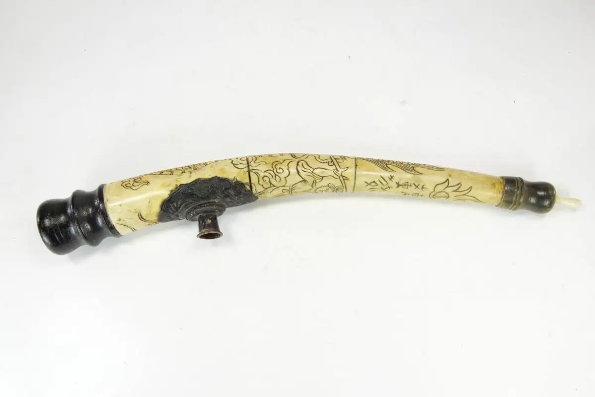 Opiumpfeife, China, 19./20. Jh., Bein, Horn, Holz und Kupfer, gebogenes Beinmittelstück, verziert mit Drachen und Schriftzeichen, als Abschluss gedrechselte Holzteile, Gebrauchsspuren, guter Zustand. L: 40 cm 1