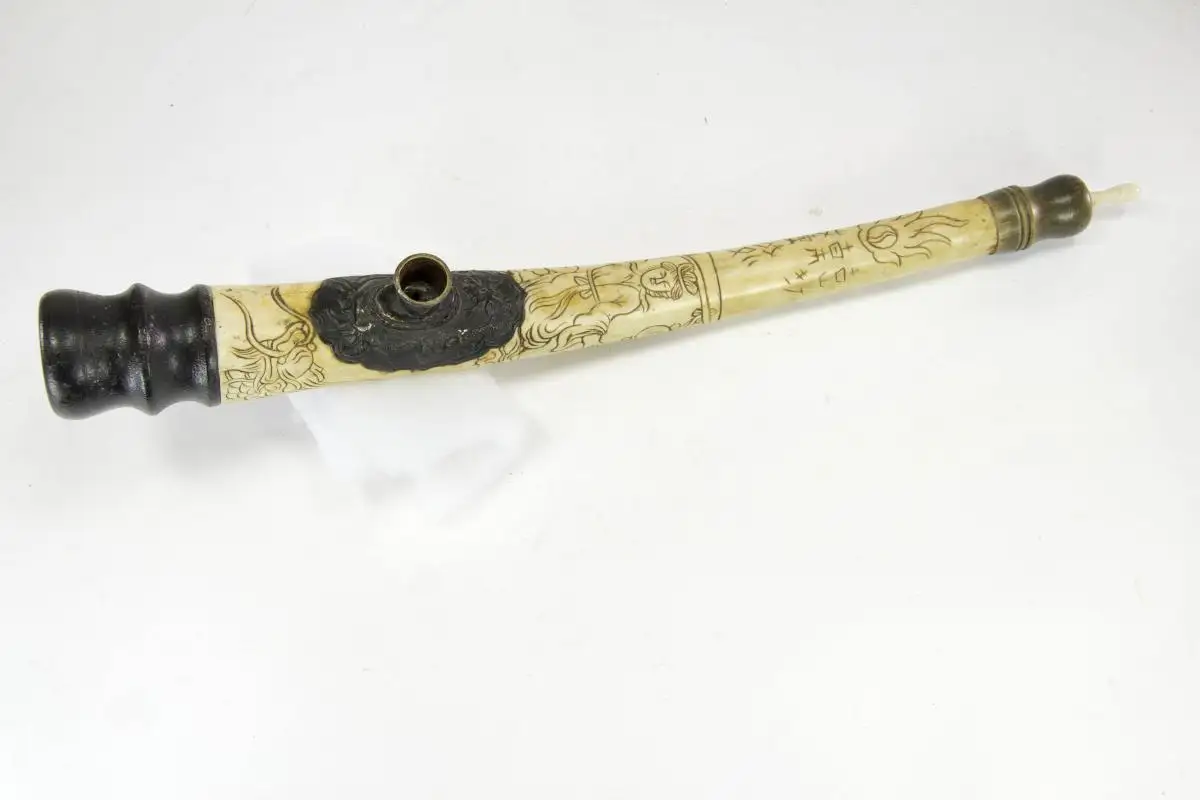 Opiumpfeife, China, 19./20. Jh., Bein, Horn, Holz und Kupfer, gebogenes Beinmittelstück, verziert mit Drachen und Schriftzeichen, als Abschluss gedrechselte Holzteile, Gebrauchsspuren, guter Zustand. L: 40 cm 2