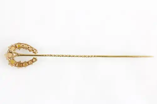 Krawattennadel, um 1900, 14 ct Gold, ungemarkt, in Form eines Hufeisens, mit Halbperlen besetzt. Tie pin, about 1900, 14 ct gold, shape of a horse shoe