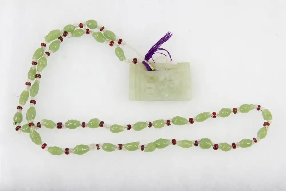 Kette, China, Anf. 20. Jh., grüne und rote Glasperlen, Jadeanhänger. L: 32 cm, 
Chain, China, 20th century, green and red glass pearls, good condition 0