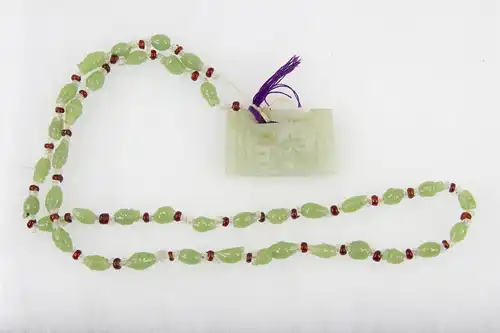 Kette, China, Anf. 20. Jh., grüne und rote Glasperlen, Jadeanhänger. L: 32 cm, 
Chain, China, 20th century, green and red glass pearls, good condition