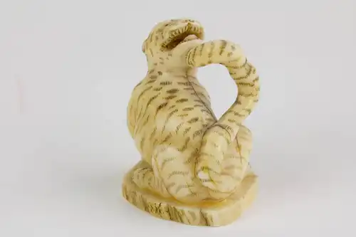 Netsuke, Japan, Meiji-Zeit, Bein, Tiger, geschnitzt und geschwärzt, signiert. H. 3,5 cm.