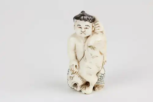 Netsuke, Japan, Anf. 20. Jh., Bein, Sumoringer mit Tiger, signiert, H: 5 cm.