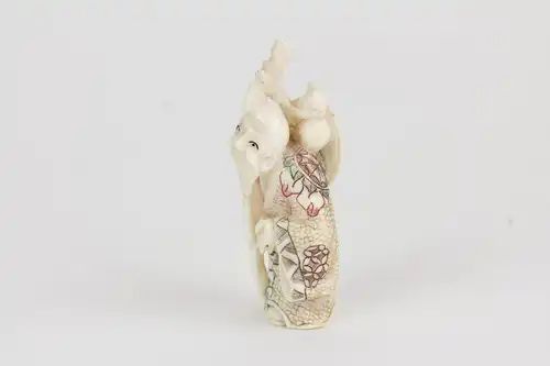 Netsuke, Japan, Anf. 20. Jh., Bein, Chokwaro mit Wanderstab und Kürbisflasche auf Schulter, farbig abgesetzt, signiert, Gebrauchsspuren, H: 6 cm.