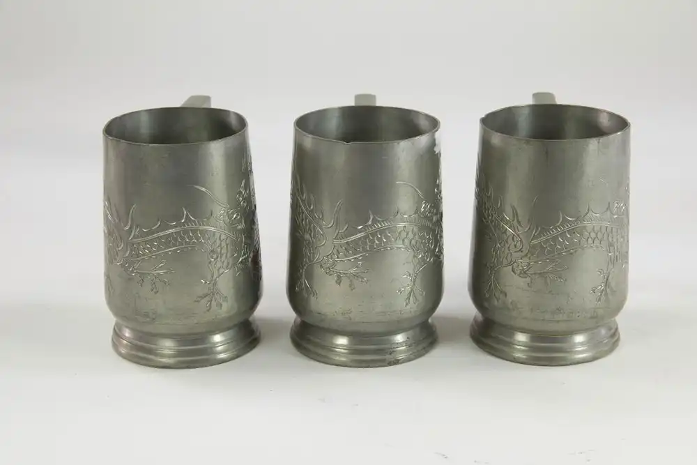 3 Zinnbecher, um 1900, China, Zinnmarke Hongkong, mit gravierten Drachen verziert, im Boden Glasscheibe, Gebrauchsspuren. H: 11 cm. 1