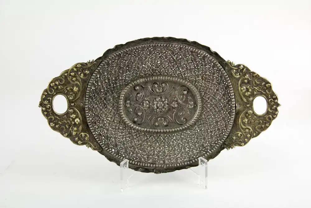 Kleine Schauplatte, 2. Hälfte 17. Jh., Silber, gestempelt Augsburg und unbekannte Marke, ovales Tablett, durchbrochen in Blütenform gearbeitet, Mittelmedaillon im Perlkranz mit Ornamenten, Handhaben floral verziert und vergoldet, Gebrauchsspuren. L:... 0